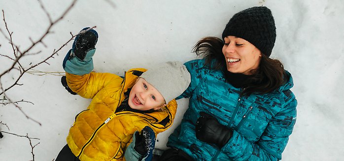 pojke och pappa kramas i snön